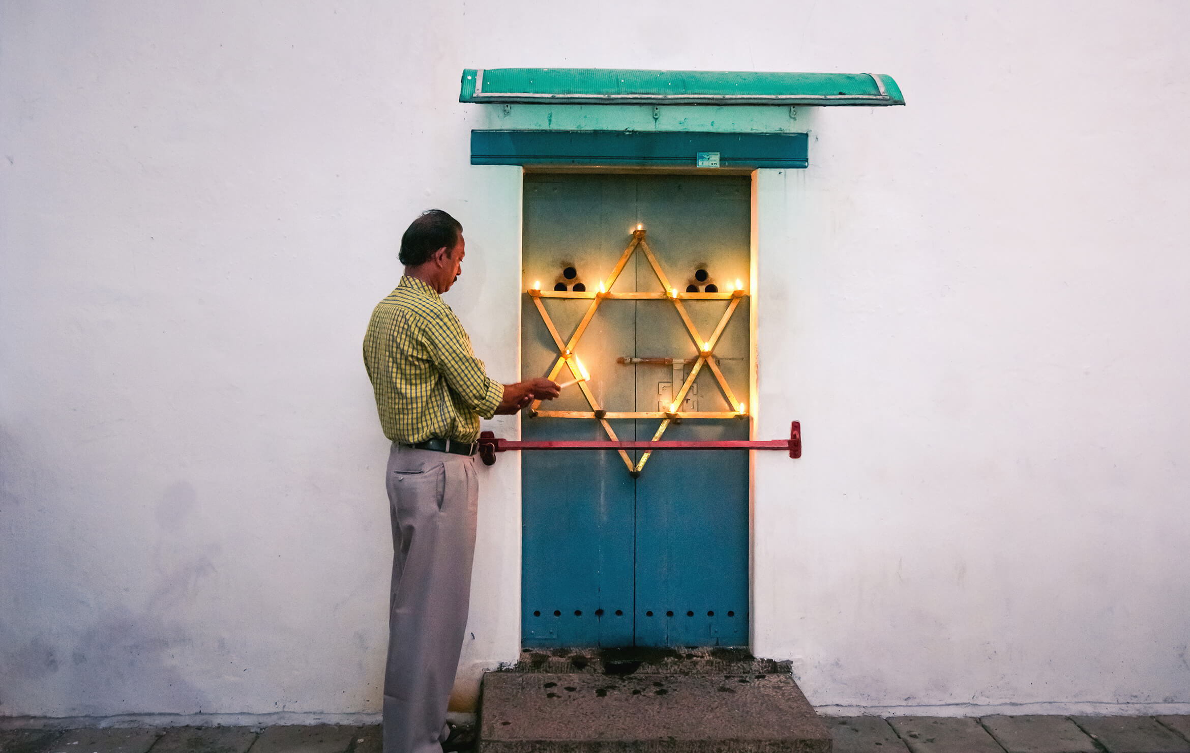 A JEWISH AUTUMN IN KOCHI -A much smaller candelabrum, shaped like the Star of David and mounted on a tiny door at the foot of the clock tower of the synagogue, is also lit.
